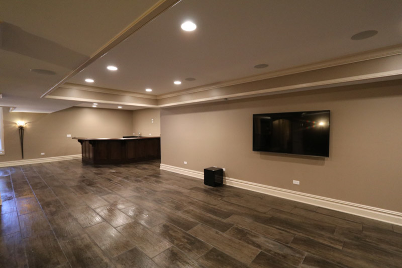 Example of a huge mountain style underground ceramic tile and gray floor basement design in Chicago with beige walls