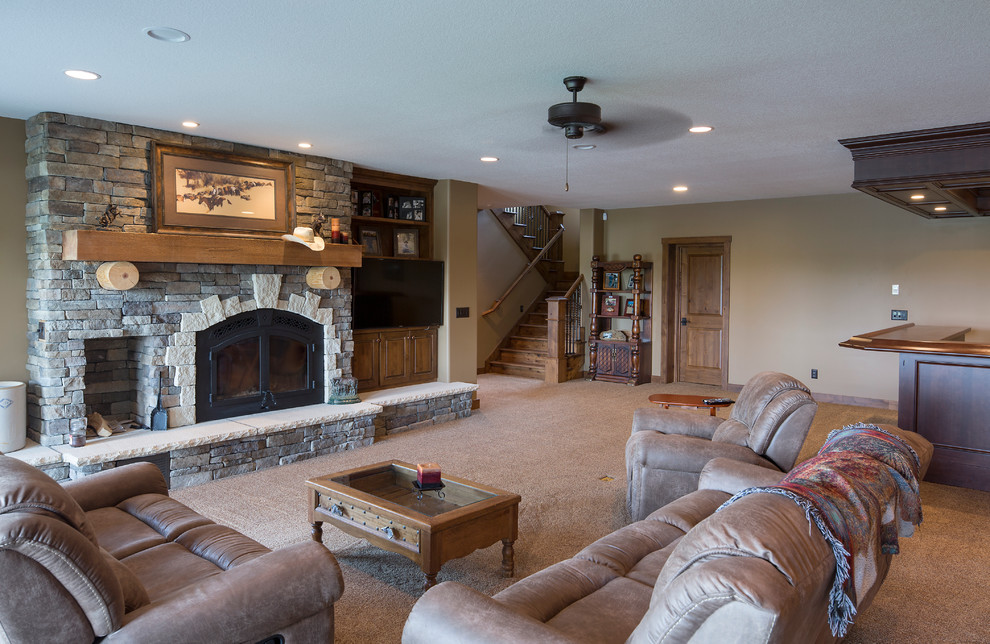 Huge mountain style walk-out carpeted and beige floor basement photo in Wichita with beige walls, a standard fireplace and a stone fireplace