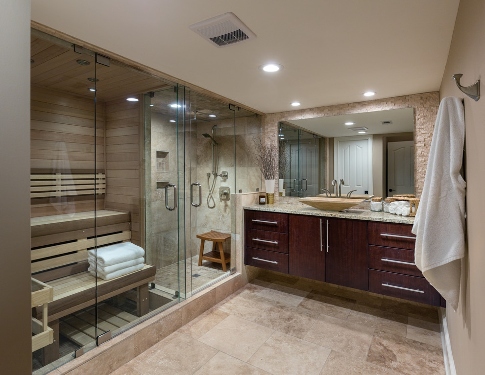 Inredning av ett modernt mellanstort vit vitt badrum, med beige väggar, travertin golv, beiget golv, bruna skåp, en kantlös dusch, beige kakel, travertinkakel, ett fristående handfat, granitbänkskiva och dusch med gångjärnsdörr