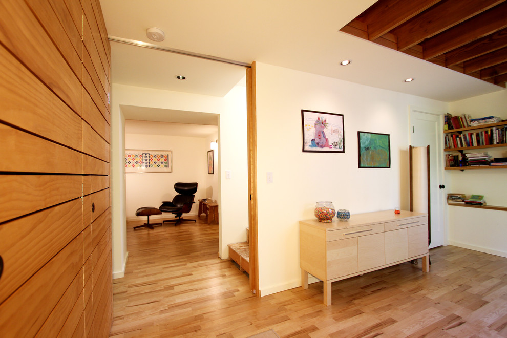 This is an example of a large classic walk-out basement in Seattle with white walls and laminate floors.