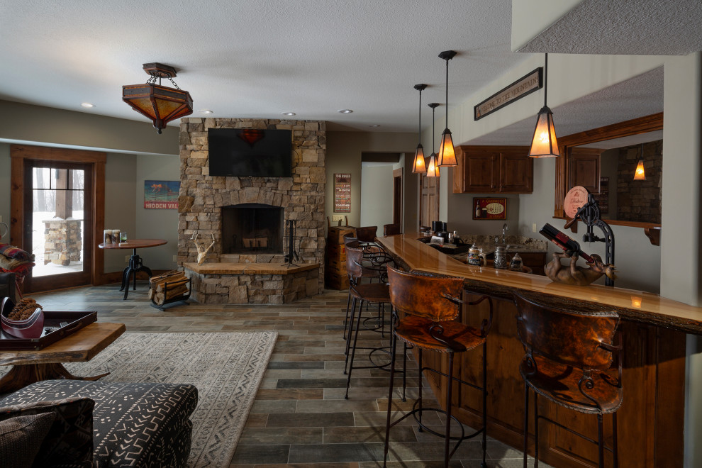 Example of a mountain style living room design with a stacked stone fireplace