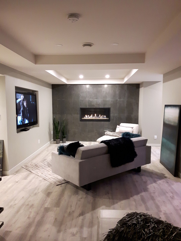 Cette image montre un sous-sol minimaliste avec cheminée suspendue et un manteau de cheminée en carrelage.