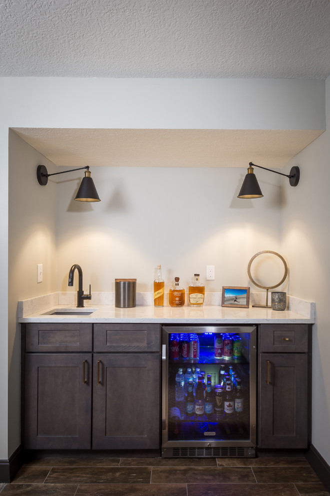 Medium sized traditional home bar in Columbus with carpet and brown floors.
