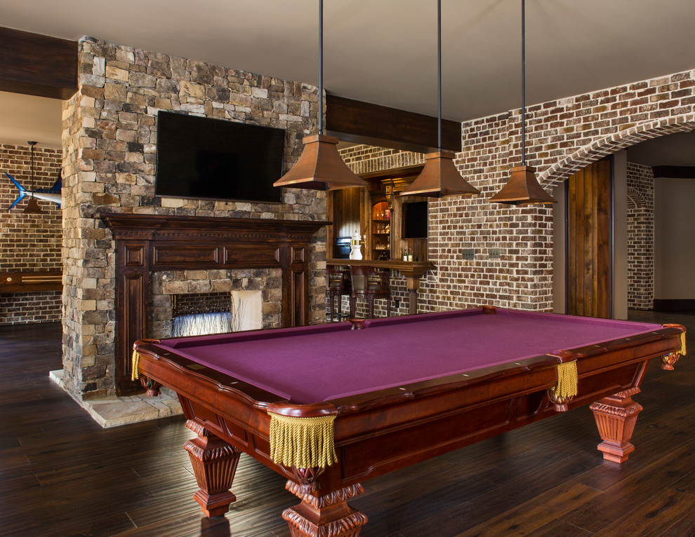 Example of a large transitional walk-out dark wood floor basement design in Atlanta with brown walls, a standard fireplace and a stone fireplace