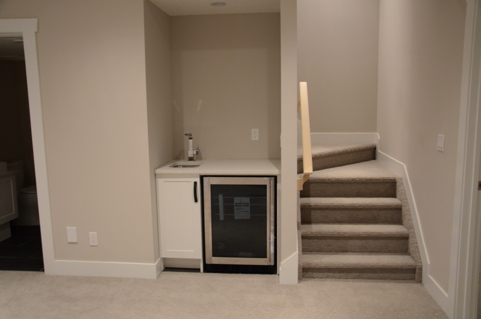 Mid-sized minimalist underground carpeted basement photo in Calgary with gray walls