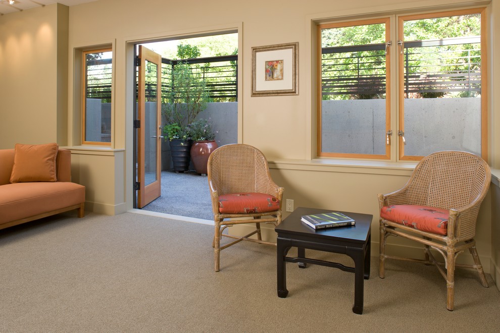 Trendy walk-out carpeted and gray floor basement photo in Seattle with beige walls
