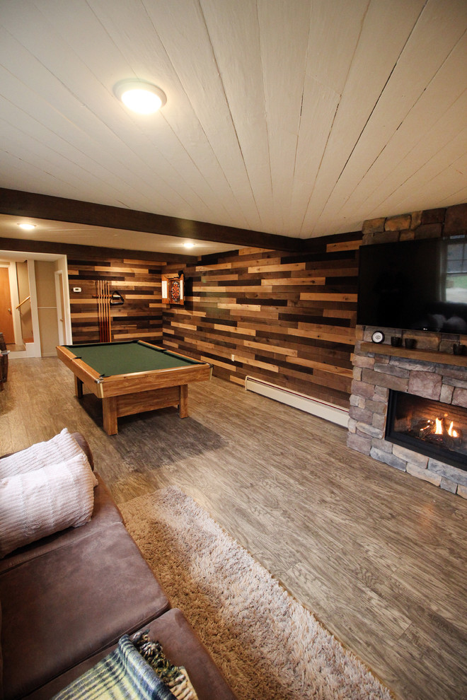 Inspiration for a large rustic look-out basement in New York with beige walls, vinyl flooring, a standard fireplace, a stone fireplace surround and grey floors.