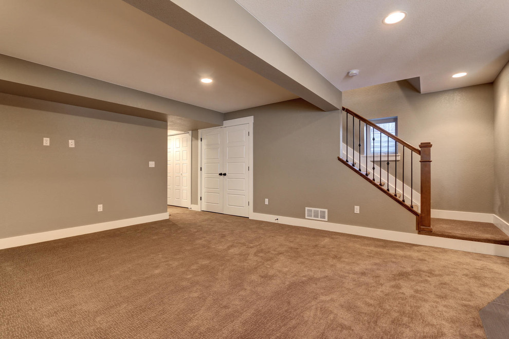 Mittelgroßes Uriges Untergeschoss mit beiger Wandfarbe und Teppichboden in Denver