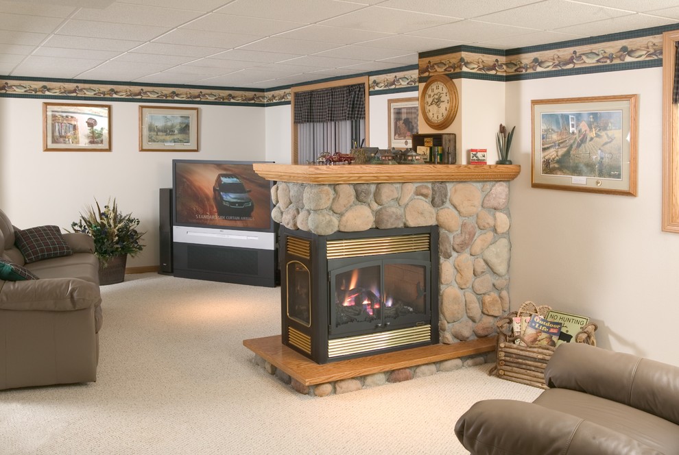 Cette photo montre un sous-sol éclectique avec une cheminée standard et un manteau de cheminée en pierre.