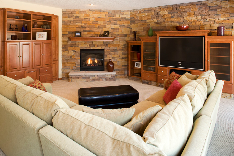 На фото: гостиная комната в классическом стиле с фасадом камина из камня, угловым камином, ковровым покрытием, бежевыми стенами и серым полом