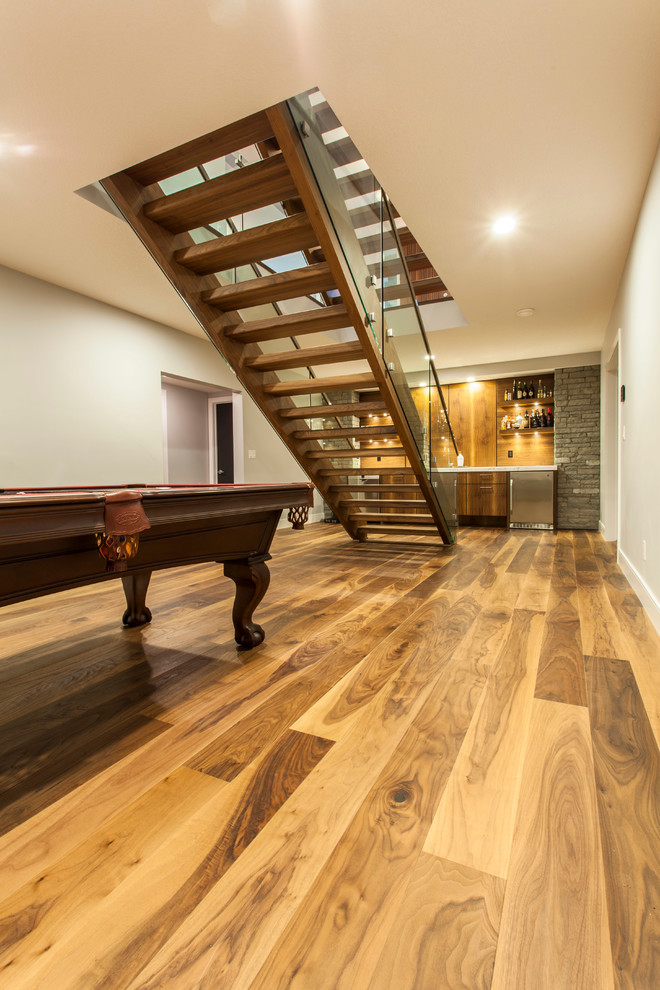 Inspiration for a contemporary underground medium tone wood floor basement remodel in Edmonton with white walls