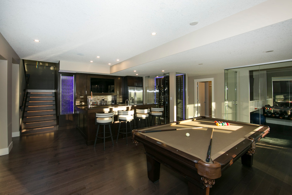 Photo of a large contemporary walk-out basement in Edmonton with beige walls and dark hardwood flooring.
