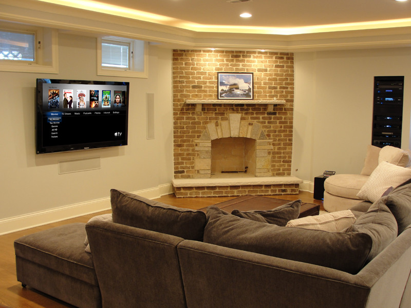Inspiration for a large timeless look-out light wood floor basement remodel in Chicago with white walls, a standard fireplace and a brick fireplace
