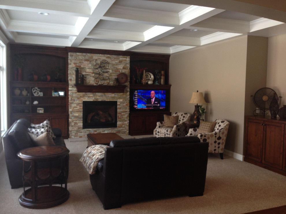 Example of a mid-sized mountain style walk-out carpeted and gray floor basement design in Minneapolis with beige walls, a standard fireplace and a brick fireplace