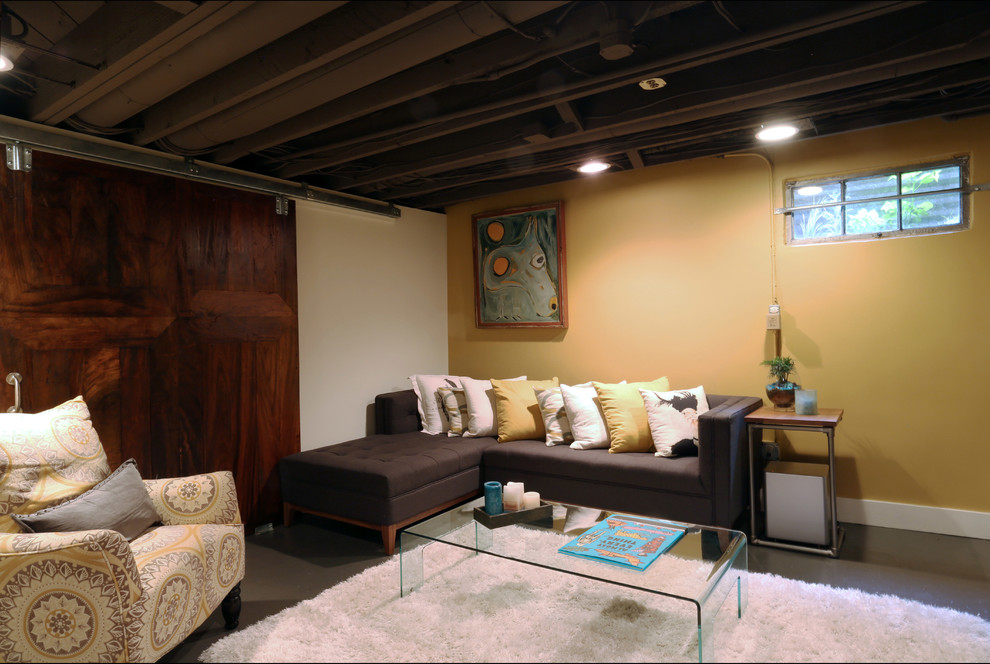 ポートランドにあるお手頃価格の小さなコンテンポラリースタイルのおしゃれな地下室 (半地下 (窓あり) 、黄色い壁、コンクリートの床、暖炉なし、グレーの床) の写真