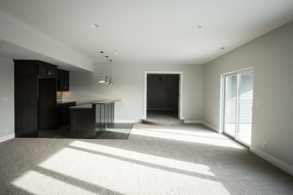 Ejemplo de sótano con puerta minimalista de tamaño medio con paredes grises y moqueta
