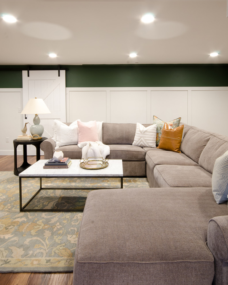Cette photo montre un grand sous-sol avec un mur vert, parquet clair et un sol marron.