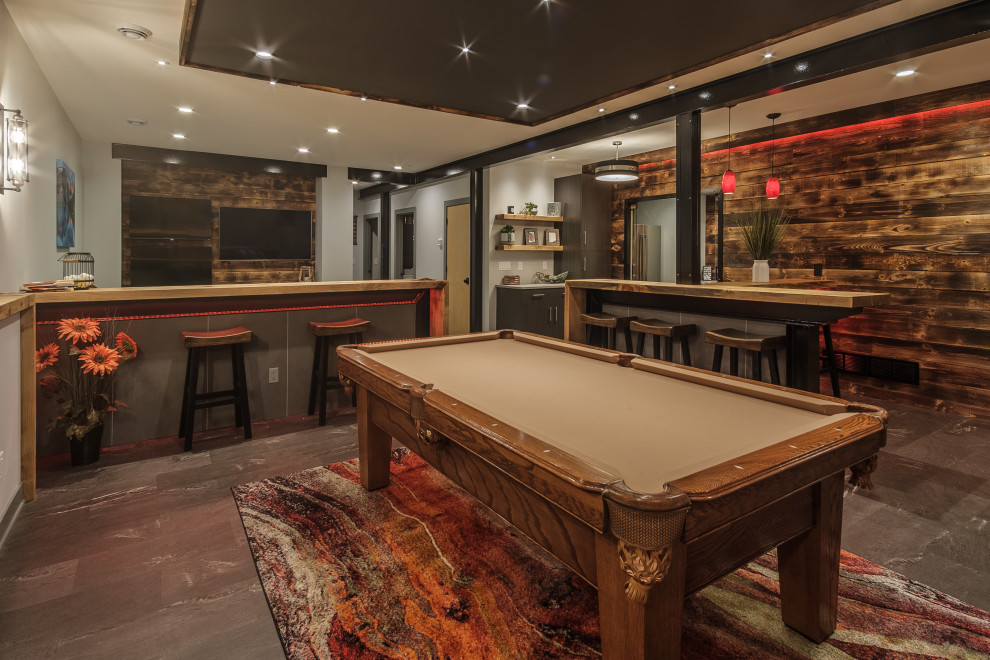 This is an example of a traditional fully buried basement in Milwaukee with a home bar, white walls, a drop ceiling, wood walls and a feature wall.