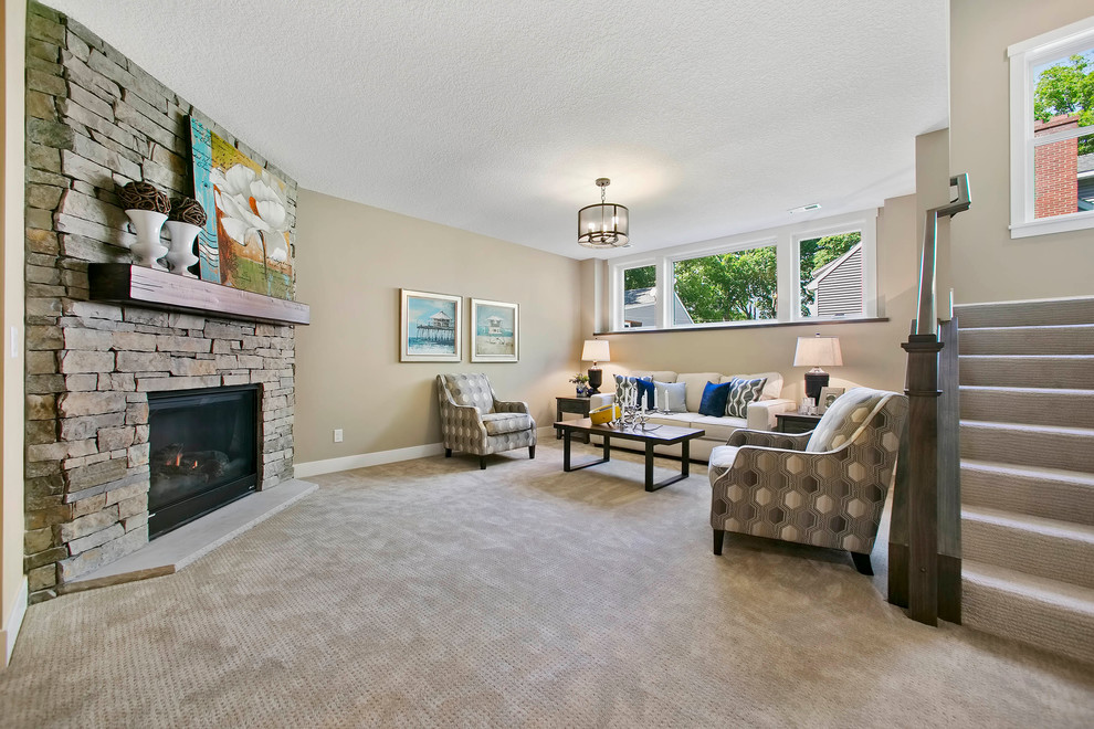 Basement - large cottage look-out carpeted basement idea in Minneapolis with beige walls, a standard fireplace and a stone fireplace