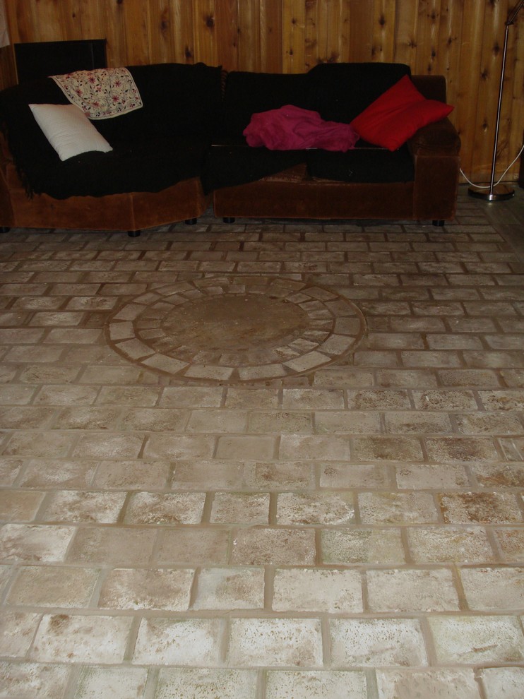 Cette image montre un grand sous-sol bohème enterré avec sol en béton ciré et un sol gris.