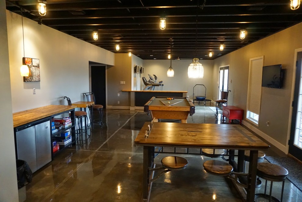 Foto di una grande taverna minimalista con sbocco, pareti grigie, pavimento in cemento, nessun camino e pavimento grigio