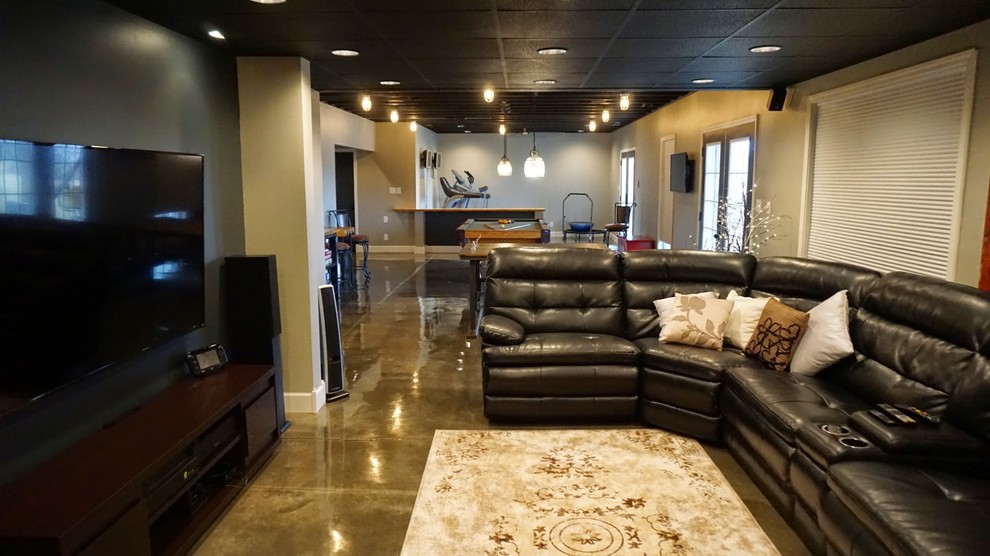Photo of a large modern walk-out basement in Louisville with grey walls, concrete flooring, no fireplace and grey floors.