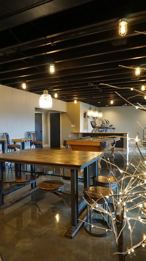 Foto di una grande taverna minimalista con sbocco, pareti grigie e pavimento in cemento