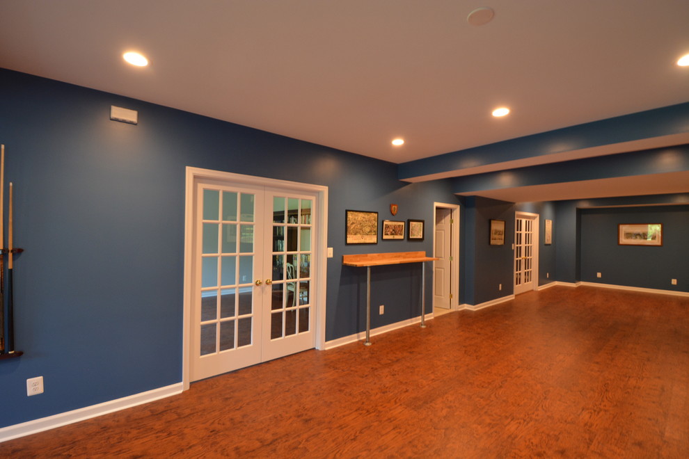 Inspiration för en stor funkis källare utan fönster, med blå väggar och mörkt trägolv