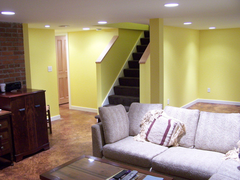 Réalisation d'un grand sous-sol design avec un sol en vinyl et un mur jaune.