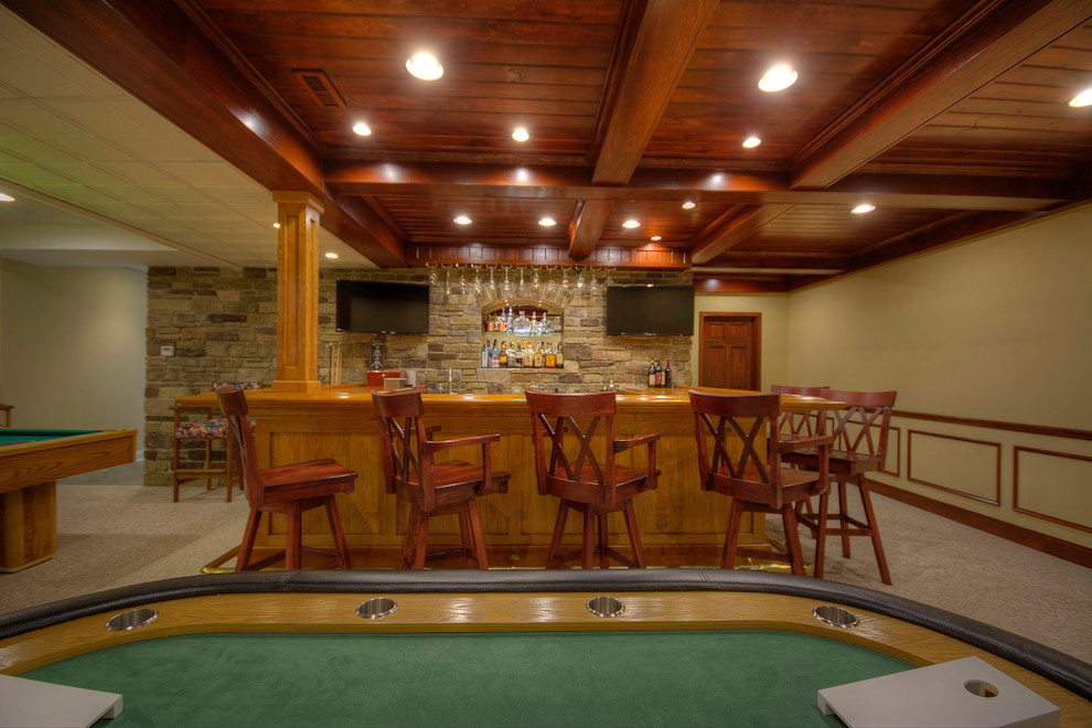 Photo of a large traditional basement in Philadelphia with beige walls, carpet and a home bar.