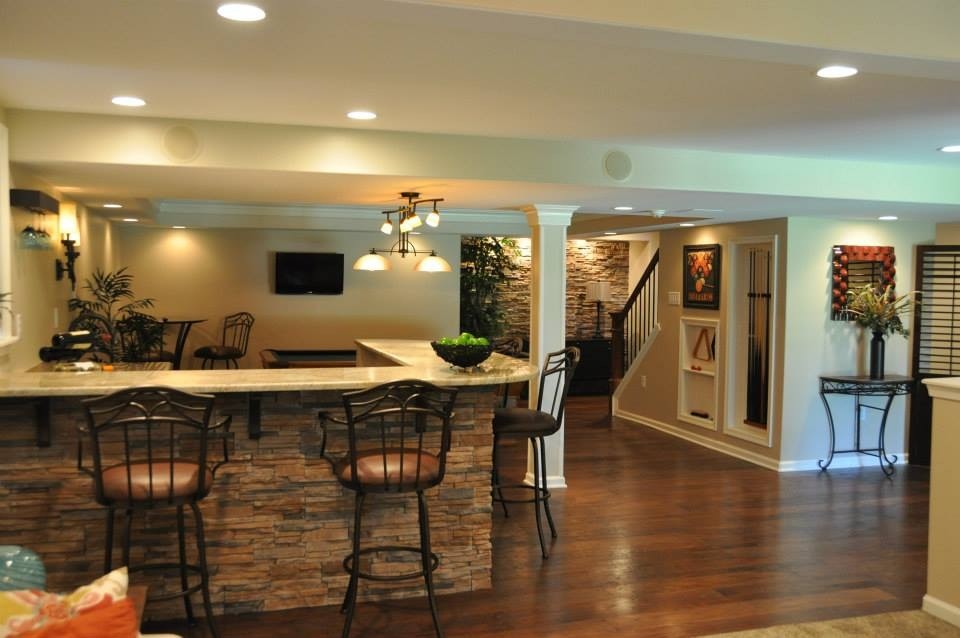 Large elegant walk-out dark wood floor and brown floor basement photo in Philadelphia with beige walls, a standard fireplace and a stone fireplace