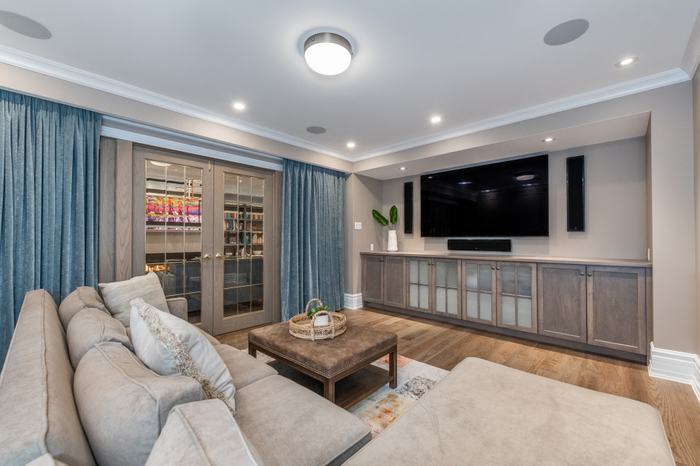 This is an example of a large modern look-out basement in Ottawa with grey walls, a tiled fireplace surround, a home cinema and brown floors.
