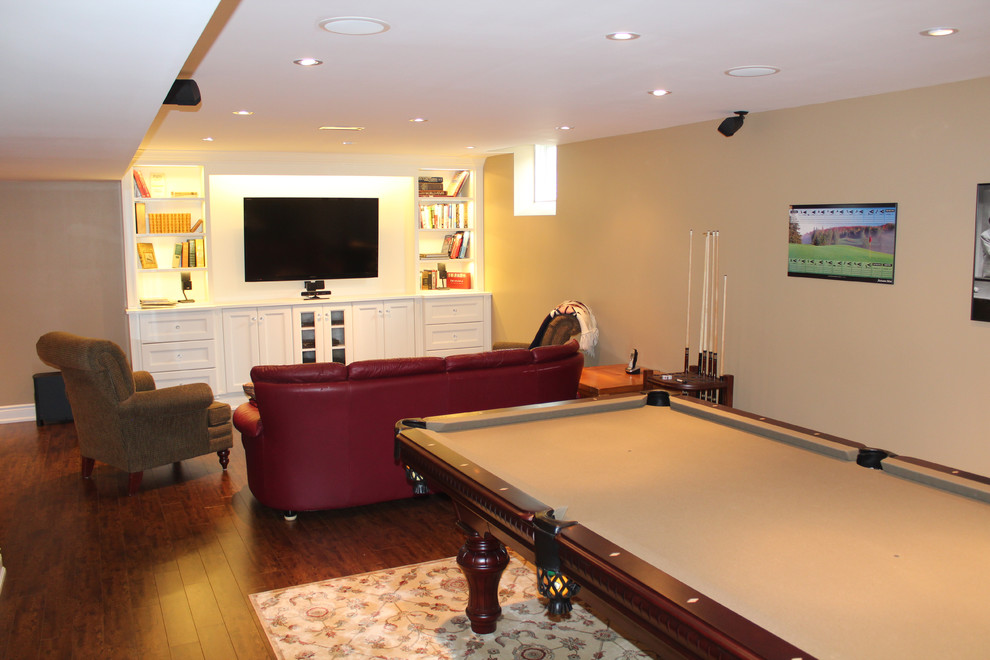 Photo of a large traditional basement in Toronto with beige walls and dark hardwood flooring.