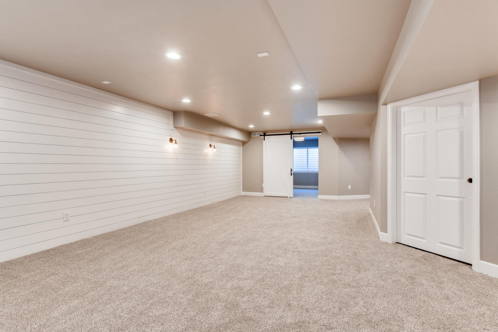 Mittelgroßer Country Keller mit weißer Wandfarbe, Teppichboden, beigem Boden und Holzdielenwänden in Denver