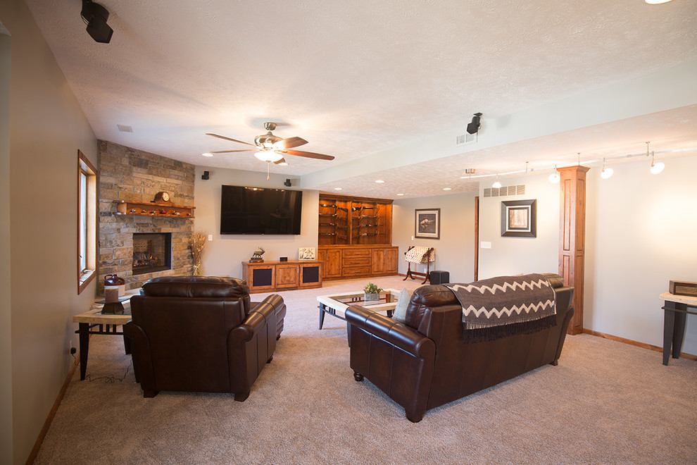 This is an example of a medium sized classic walk-out basement in Omaha with beige walls, carpet, a corner fireplace, a stone fireplace surround and grey floors.