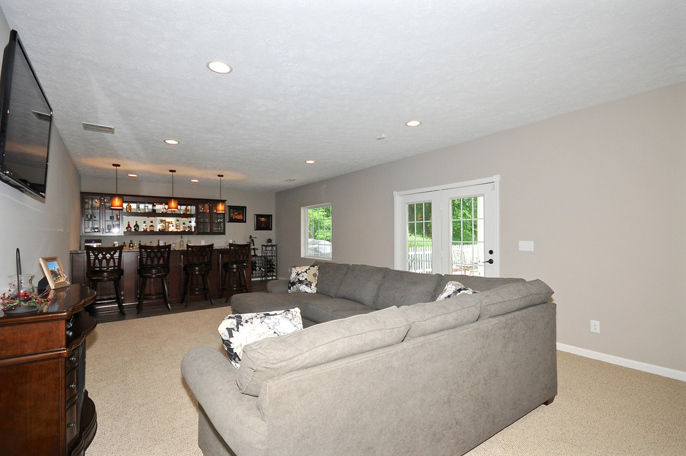 This is an example of a large contemporary walk-out basement in Indianapolis with grey walls, carpet and no fireplace.