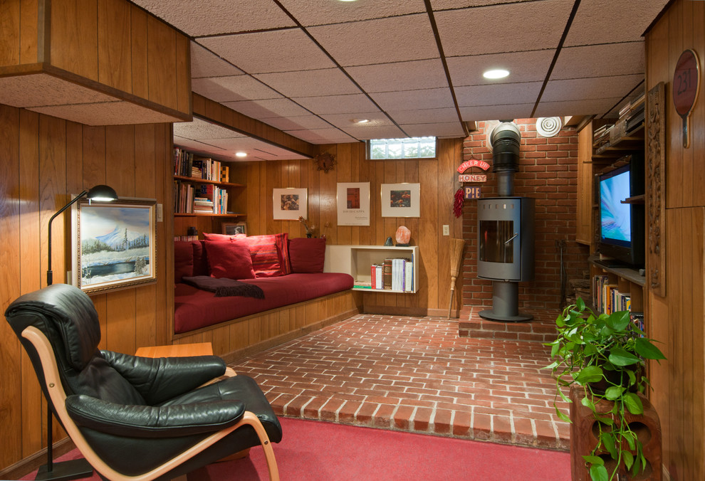 This is an example of a small retro look-out basement in Detroit with a wood burning stove, brick flooring and red floors.