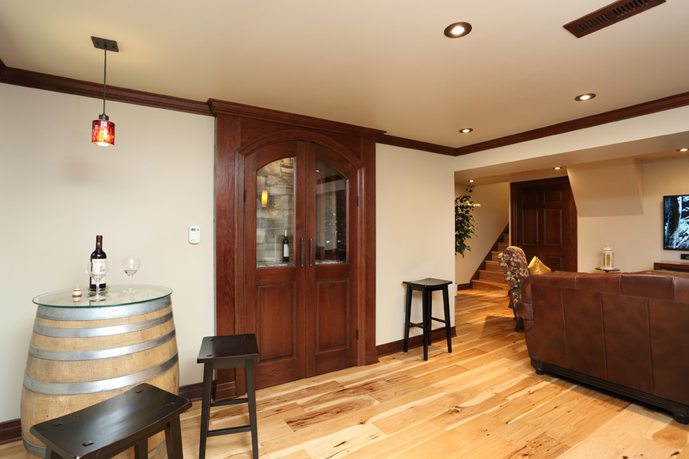 Medium sized traditional look-out basement in Toronto with beige walls and light hardwood flooring.