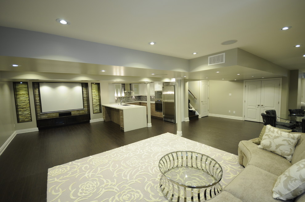 This is an example of a large contemporary fully buried basement in Toronto with grey walls and dark hardwood flooring.