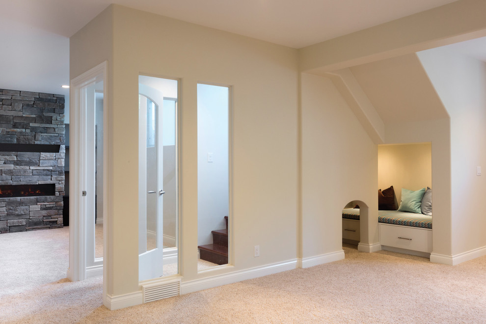 Inspiration pour un grand sous-sol minimaliste semi-enterré avec un mur beige, moquette, une cheminée ribbon et un manteau de cheminée en pierre.