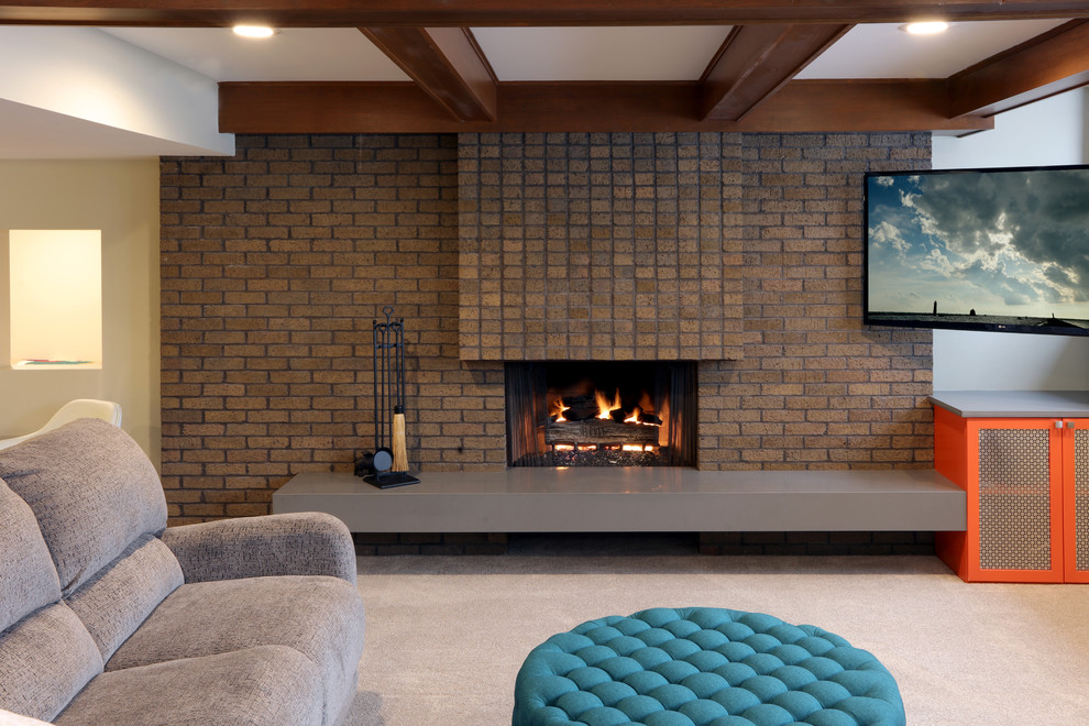Inspiration for a medium sized midcentury look-out basement in Grand Rapids with white walls, light hardwood flooring, a standard fireplace, a brick fireplace surround and beige floors.