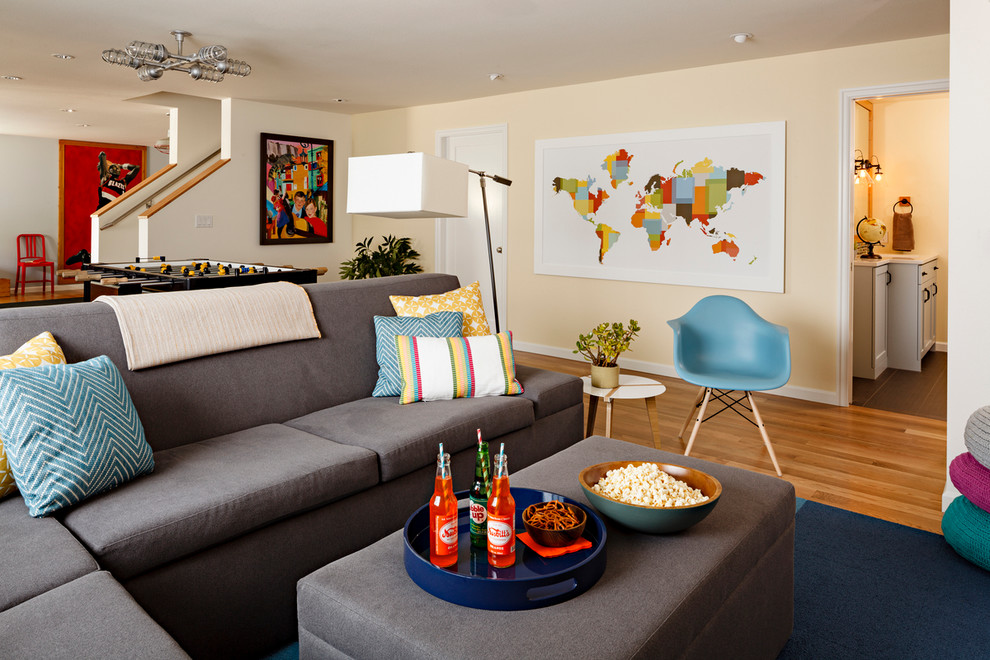 Inspiration for a transitional medium tone wood floor and orange floor family room remodel in Portland with beige walls and no fireplace