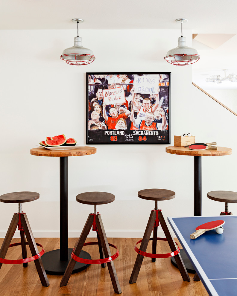 Trendy medium tone wood floor game room photo in Portland with white walls