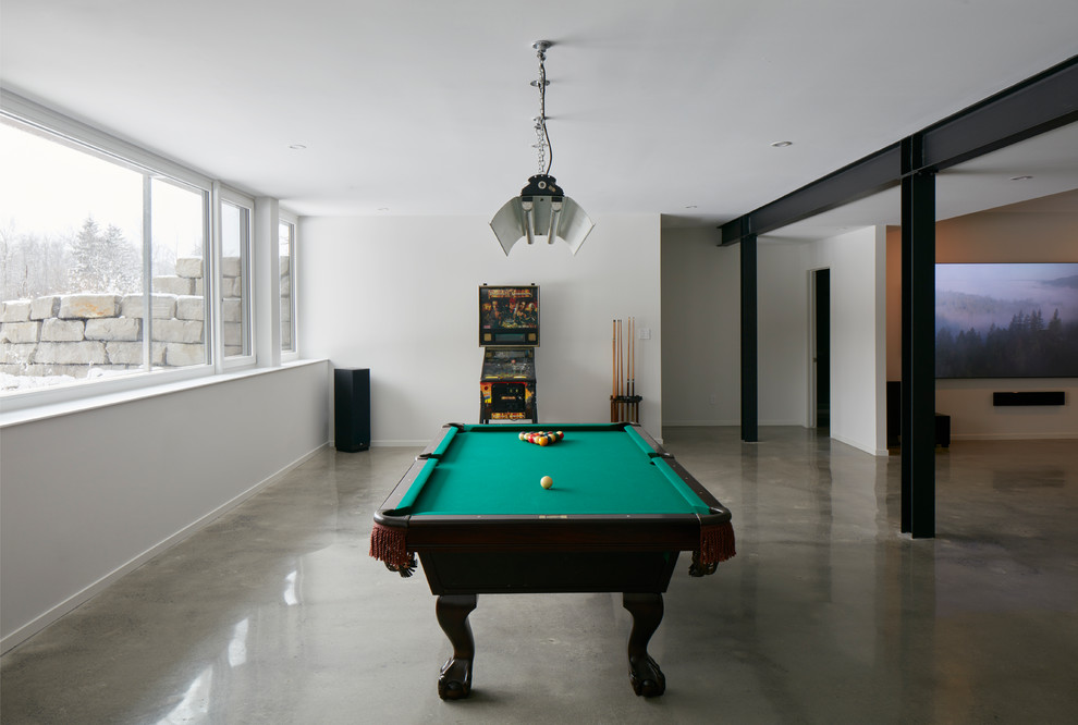 Photo of an expansive urban look-out basement in Ottawa with white walls, concrete flooring and grey floors.
