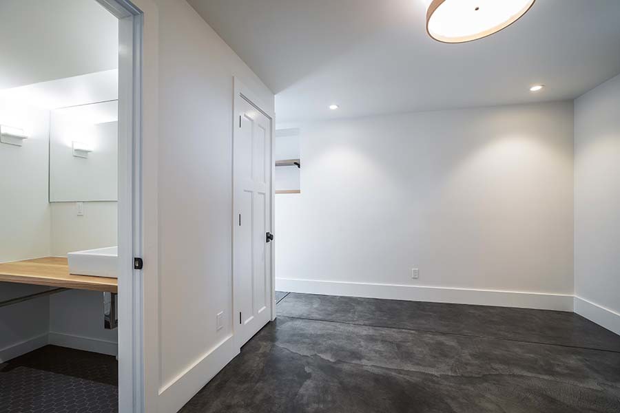 Idée de décoration pour un sous-sol minimaliste donnant sur l'extérieur avec un mur blanc, sol en béton ciré et un sol gris.