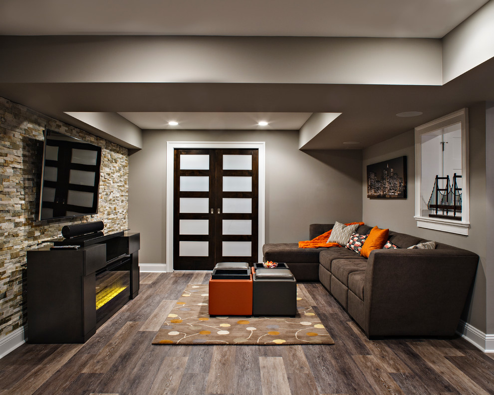 Large contemporary fully buried basement in New York with beige walls, dark hardwood flooring and brown floors.