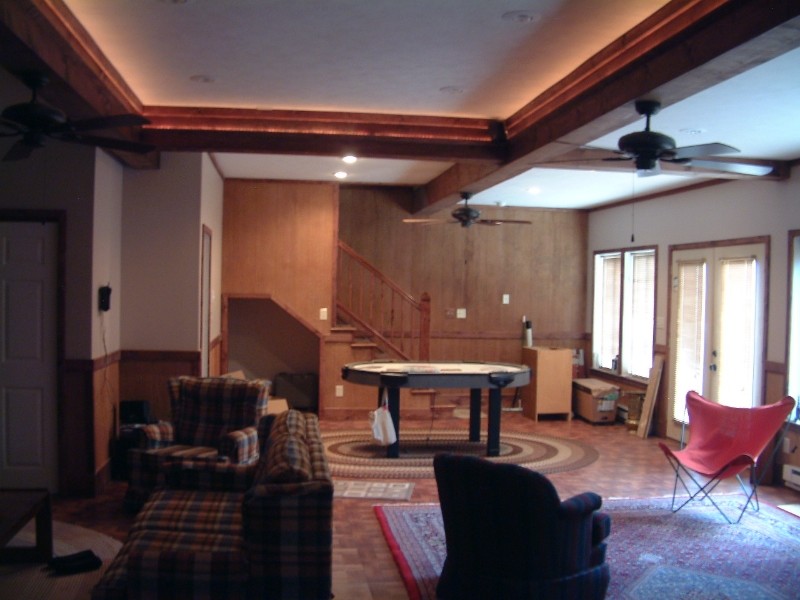 Exempel på en modern källare, med vita väggar och mellanmörkt trägolv