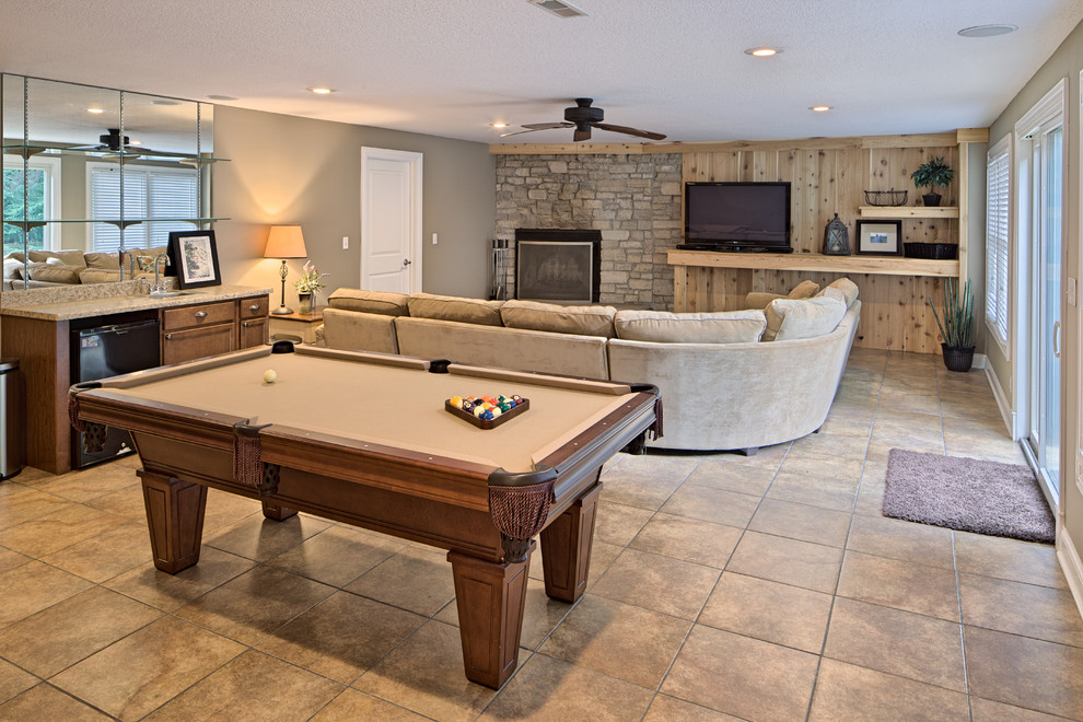 This is an example of an expansive traditional walk-out basement in Chicago with beige walls, ceramic flooring, a standard fireplace and a stone fireplace surround.