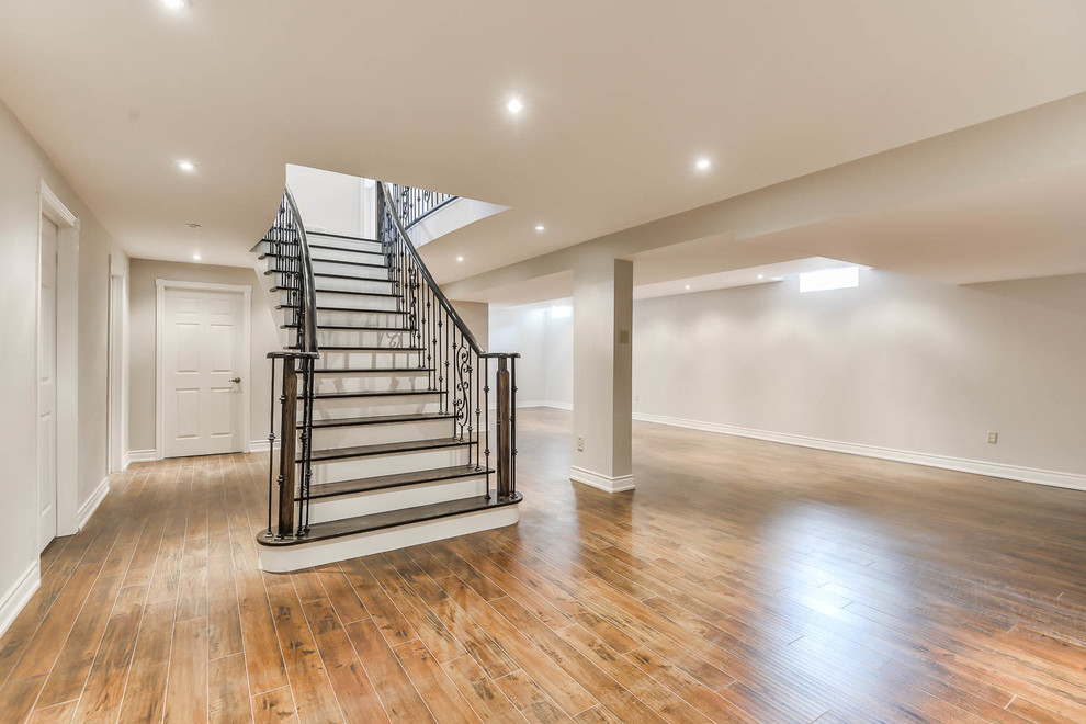 Large minimalist look-out vinyl floor basement photo in Toronto with gray walls