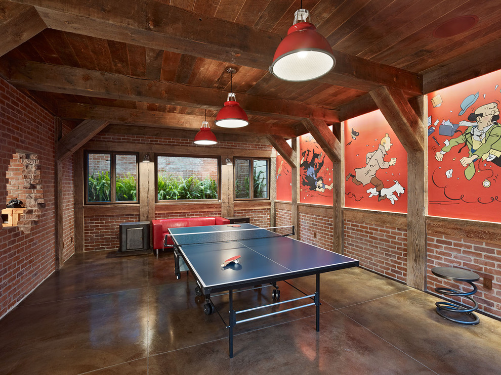 This is an example of an eclectic games room in San Francisco with concrete flooring, multi-coloured walls, no fireplace and brown floors.